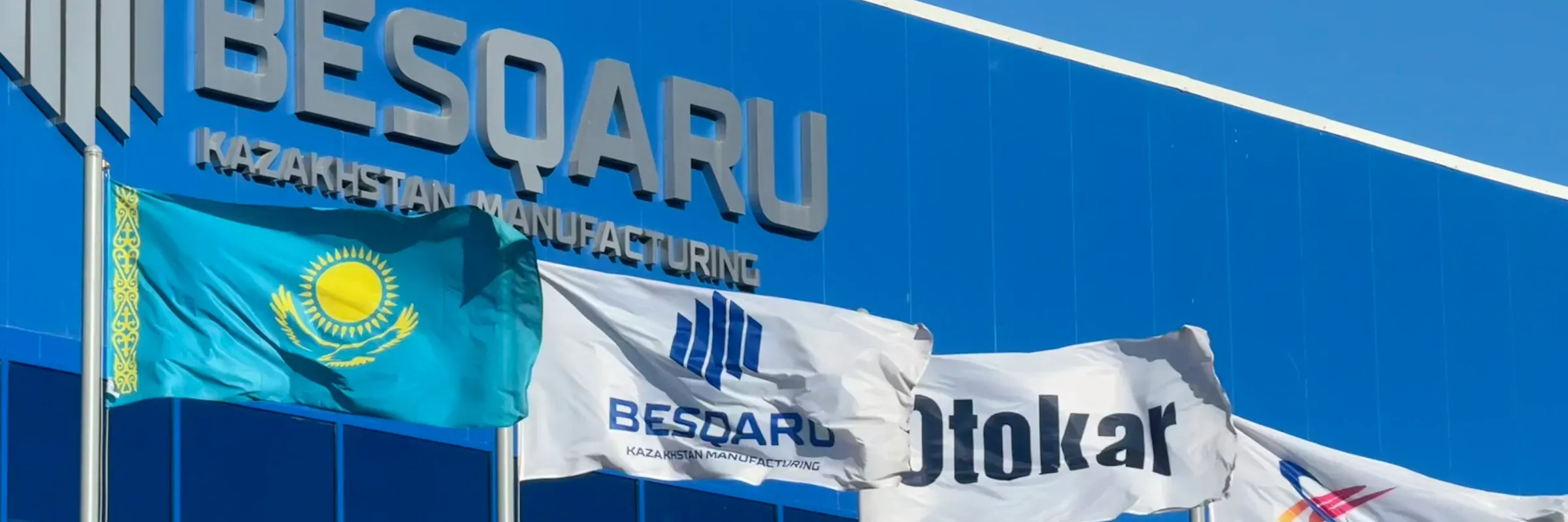 BESQARU plant facade with national and partner flags